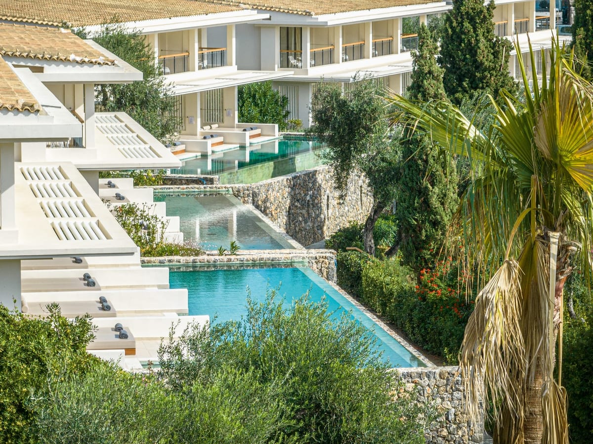 Terraced swim-up bungalow suites with shared pools among olive trees